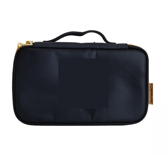 Black travel case with gold zipper on a white background